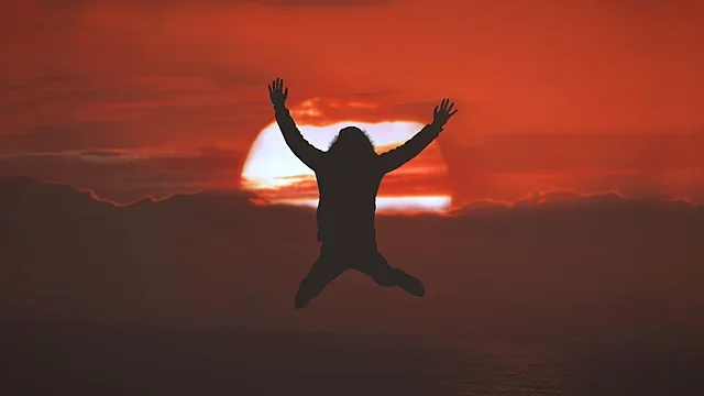 Silhouette of a jumper against a blazing red sunset