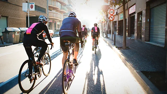 Cyclists riding into bright backlight on a city street