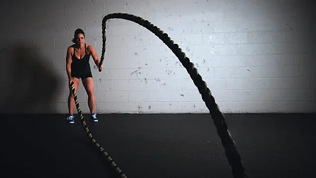 Athlete training with heavy battle ropes in a minimalist gym