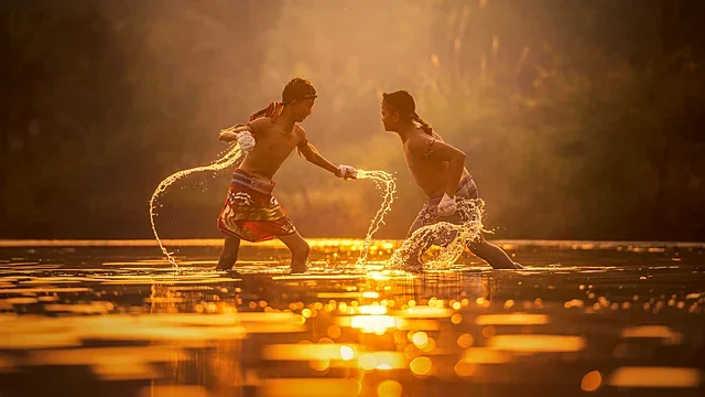 Two boxers sparring in shallow water at golden sunset