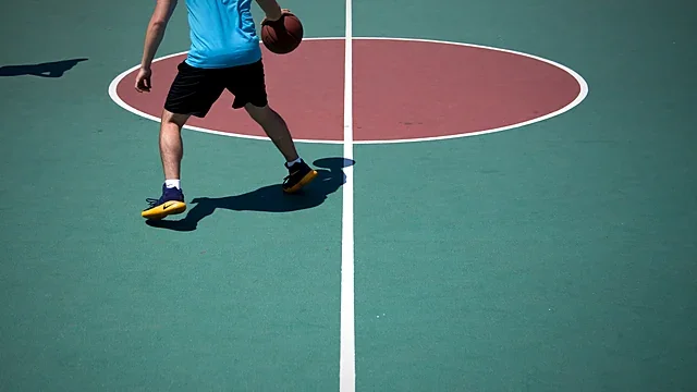 Overhead view of a basketball player on a teal court