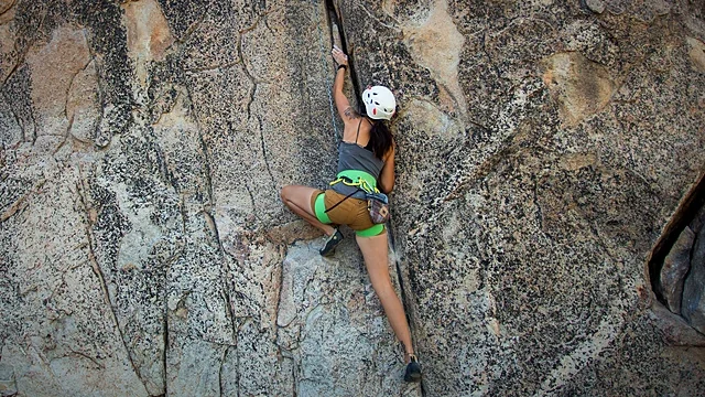 Climber scaling a sheer granite wall