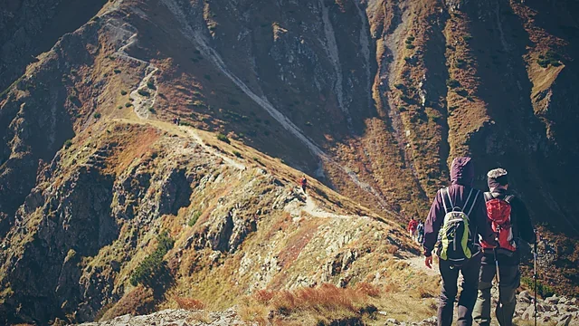 Mountaineers crossing a sunny highland valley