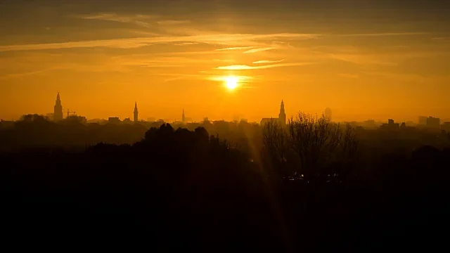City skyline glowing under a yellow sunrise