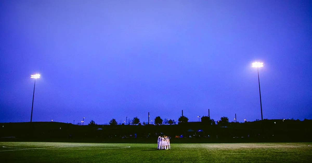 Soccer players training under stadium lights at night