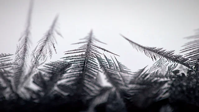 Frost crystals sparkling on a dark surface