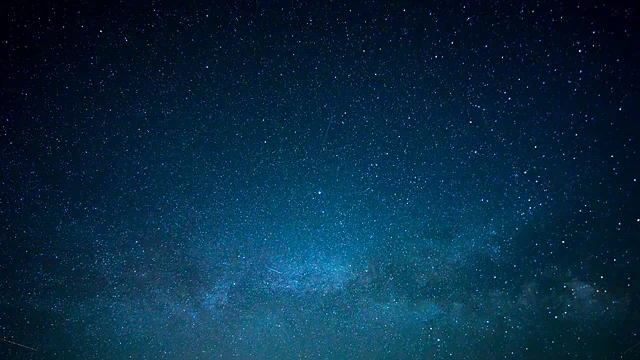 Night sky filled with stars above a quiet horizon