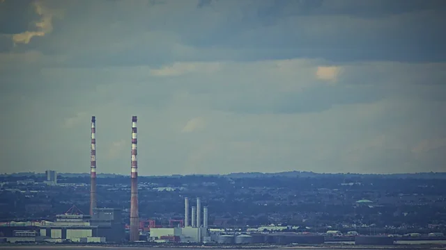 Coastal industrial chimneys against a pale sky