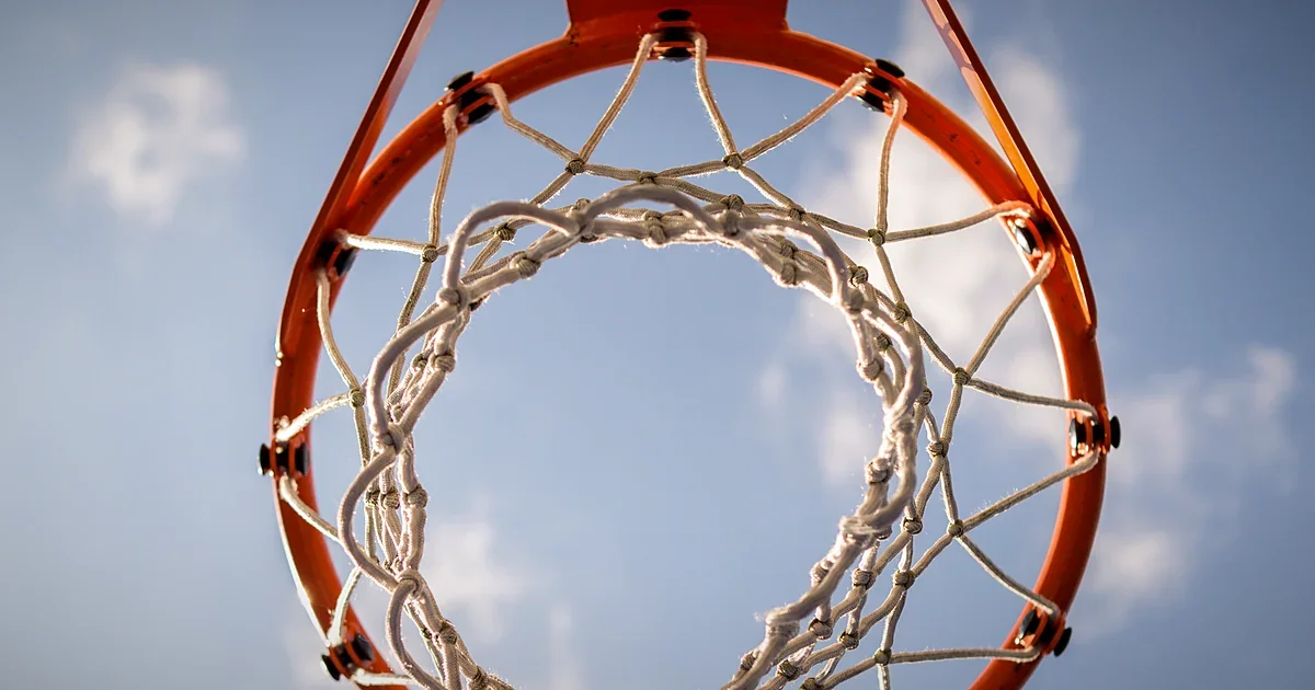 Basketball net hanging against a bright sky
