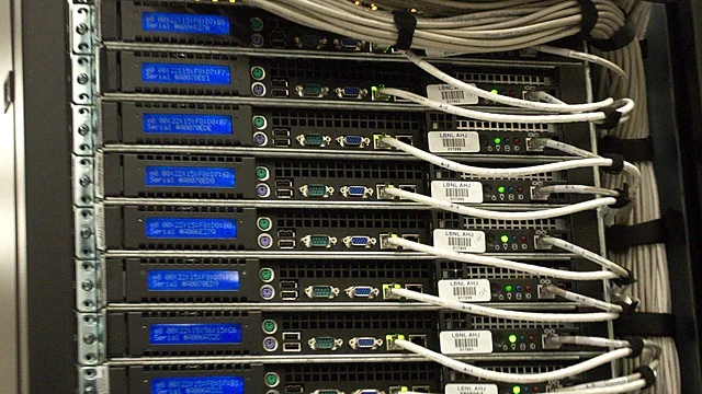 Rack of computing servers with blue indicator displays and network cables