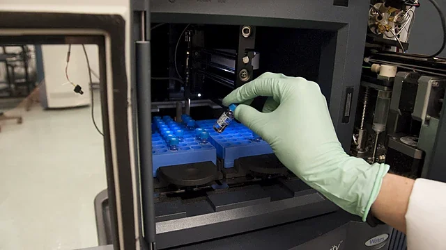 Sample tray being loaded into an instrument autosampler under blue light