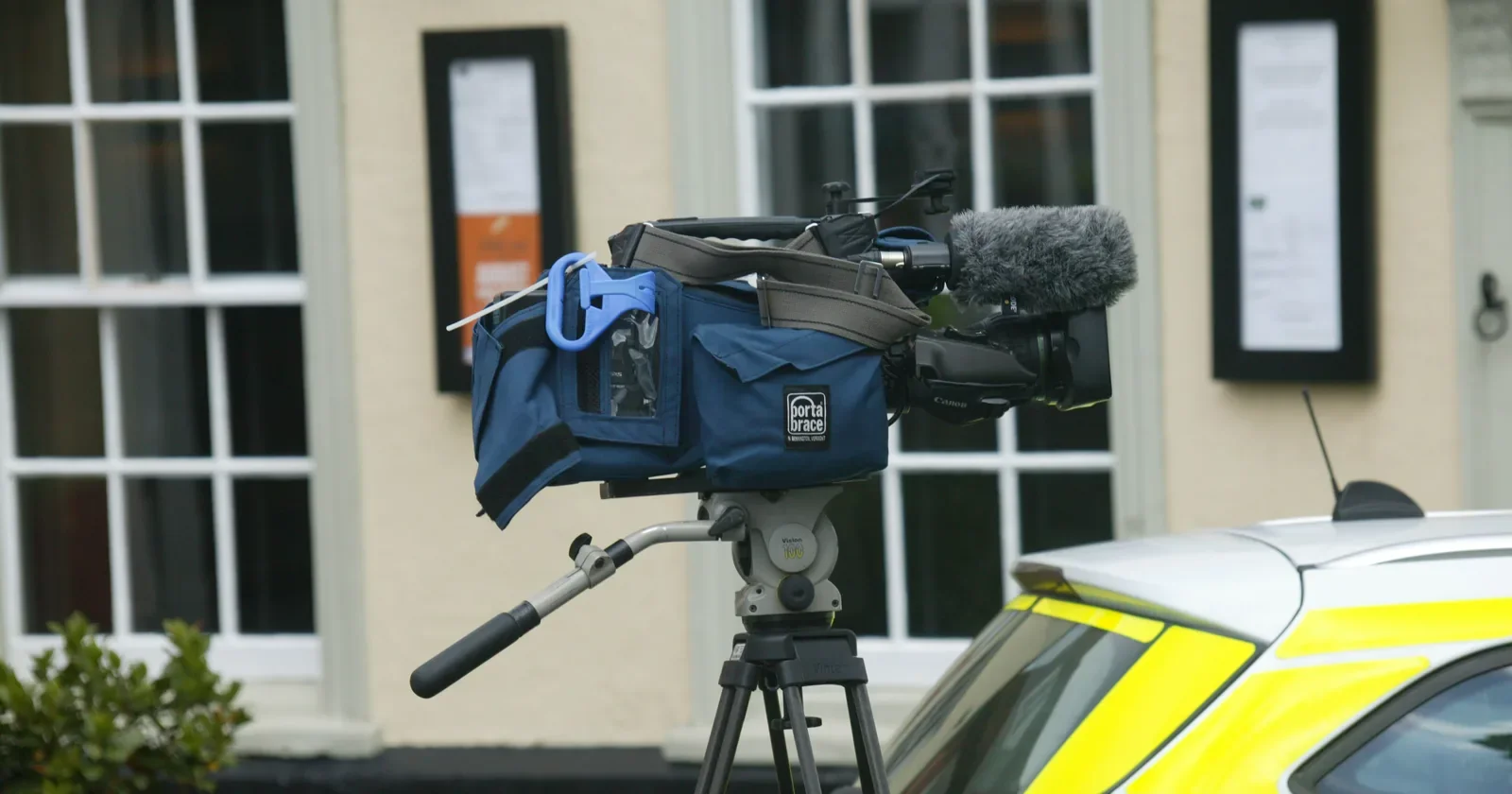 Broadcast video camera on a tripod outside a building