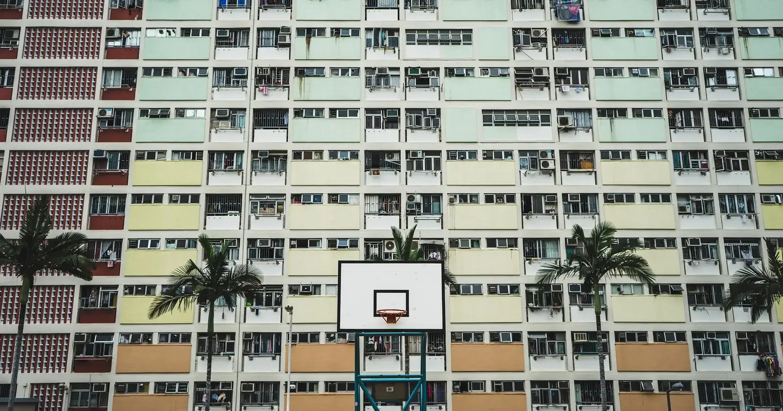 Basketball hoop in front of a pastel-coloured housing estate in Hong Kong