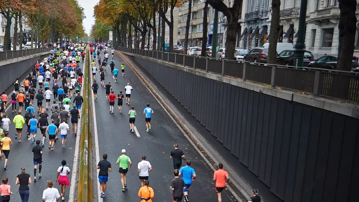 Marathon runners filling a tree-lined city road in Brussels