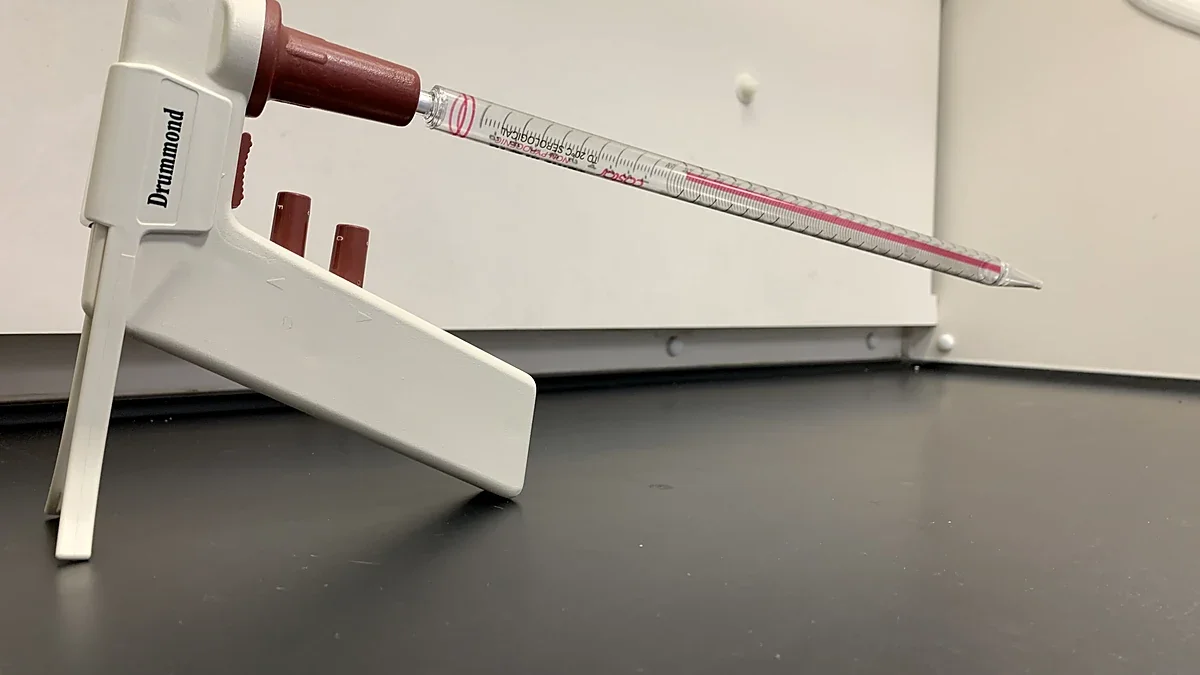 Graduated serological pipette resting on a laboratory bench