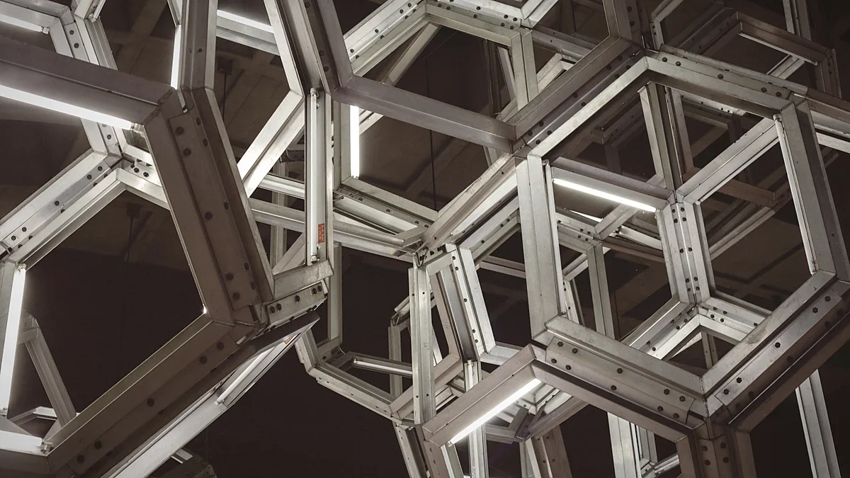 Interlocking hexagonal metal lattice lit against a dark sky