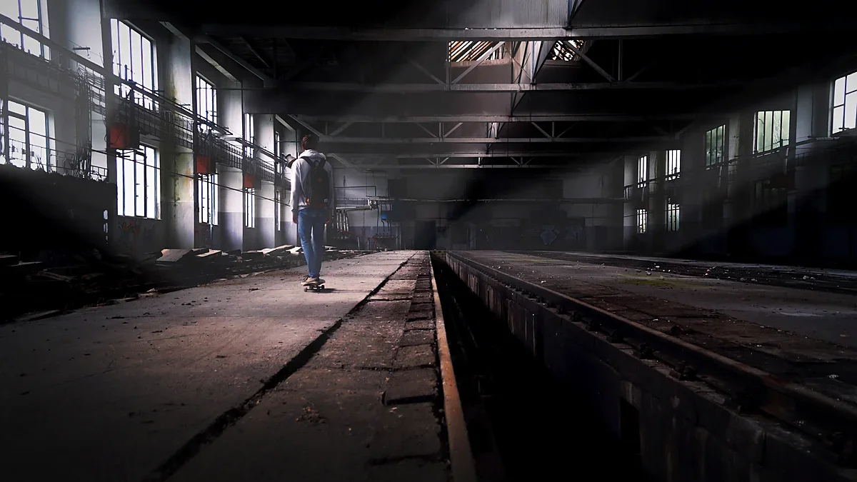 Long industrial production hall lit by shafts of light
