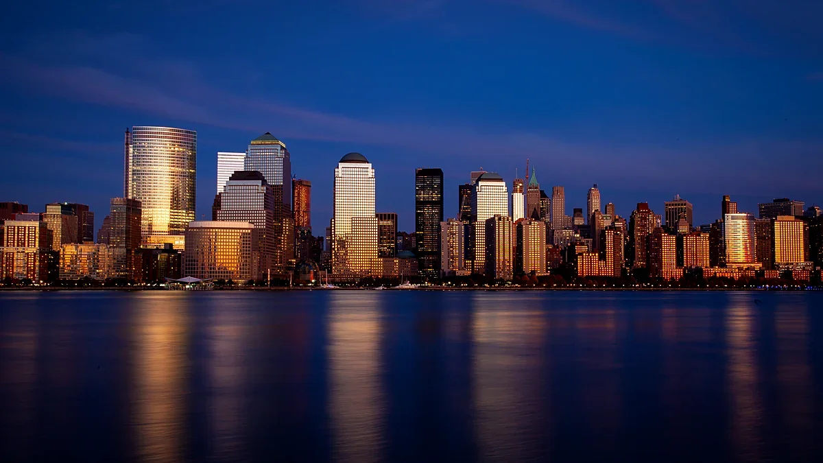 City skyline at blue hour with lit towers reflected in the river