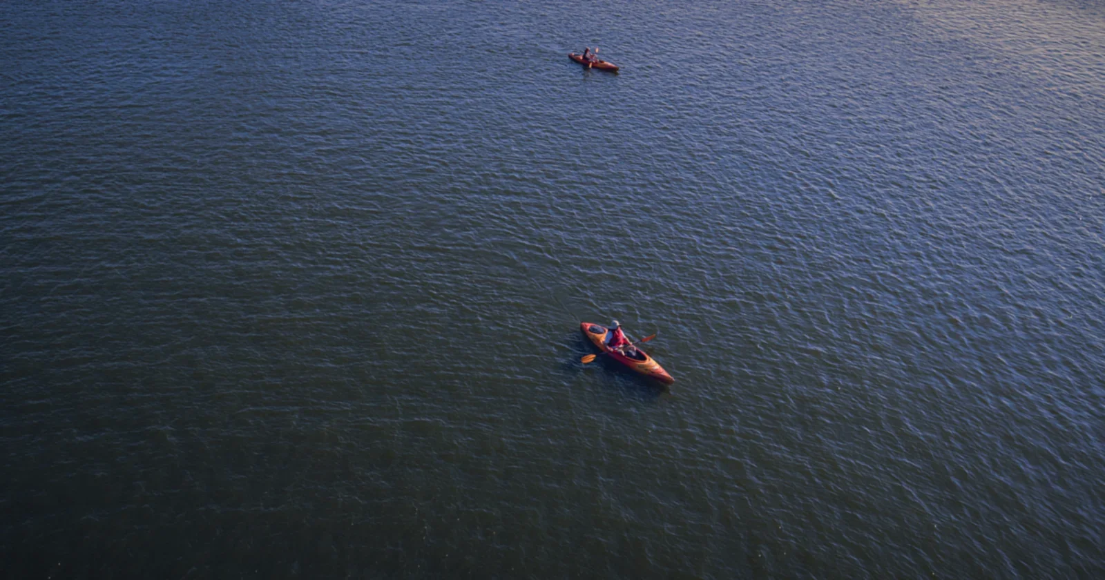 Kayaker paddling across a calm lake