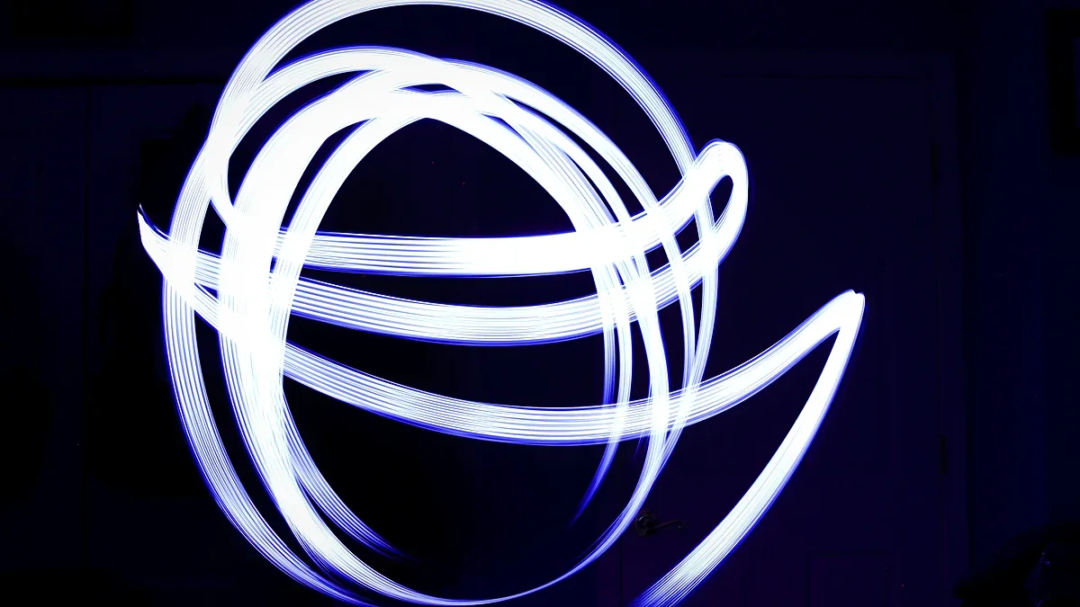 Streaks of glowing light curving across a dark background