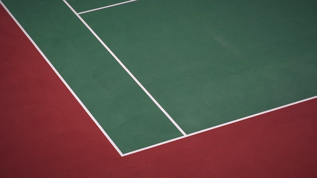 Empty tennis pitch lines under an open sky
