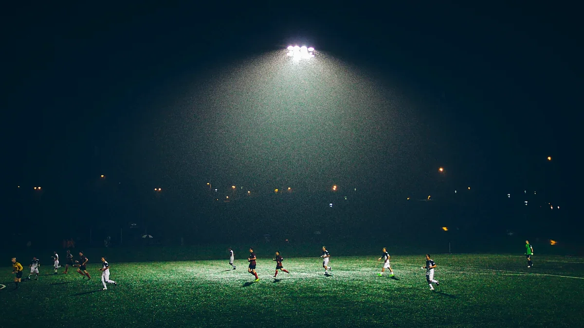 Athletes on a floodlit soccer field at night