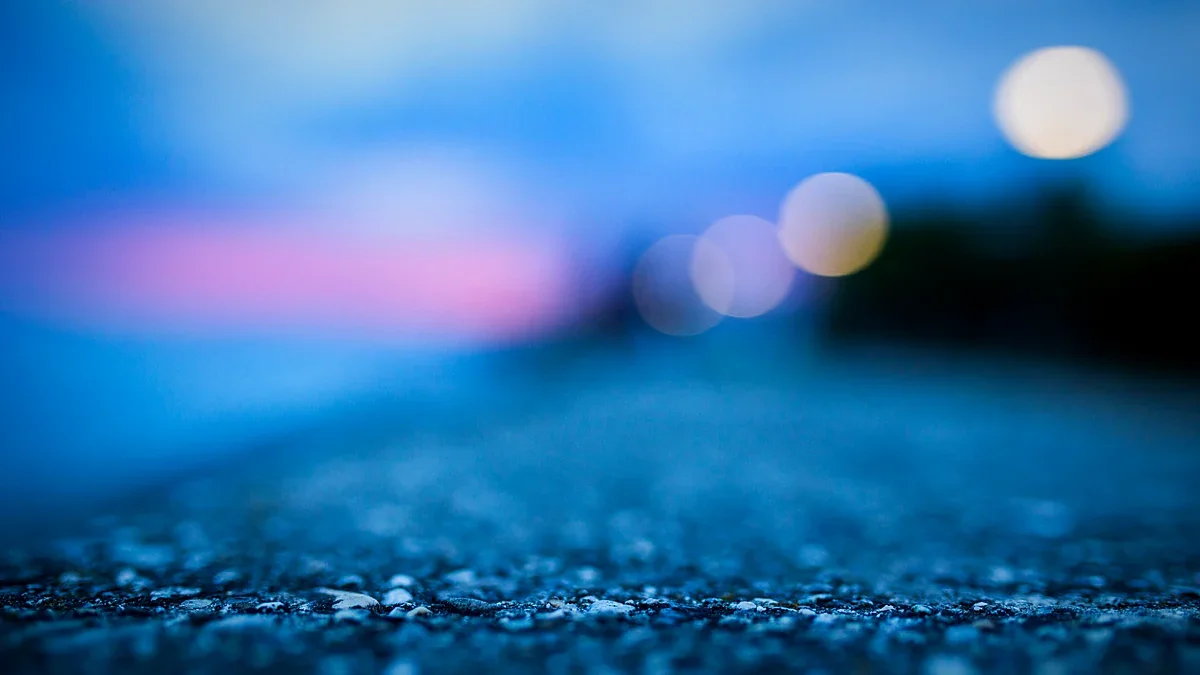 Blurred blue dusk lights over a textured pavement