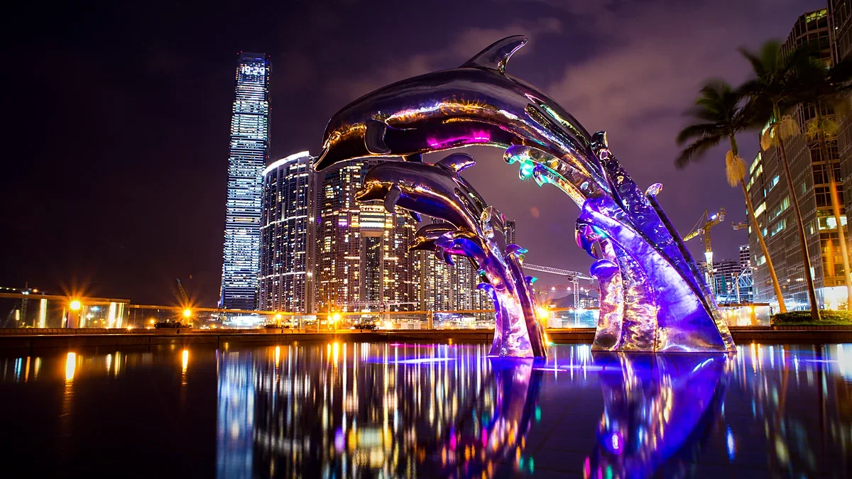 City towers lit at night above a reflecting pool