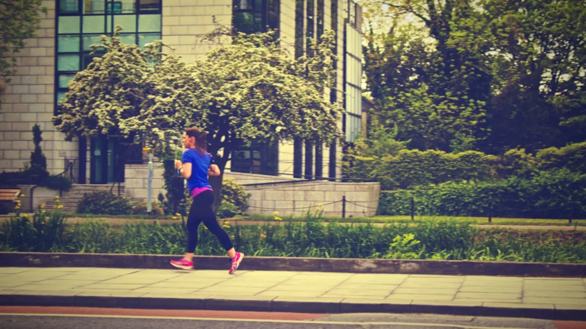 Runner striding along a city sidewalk
