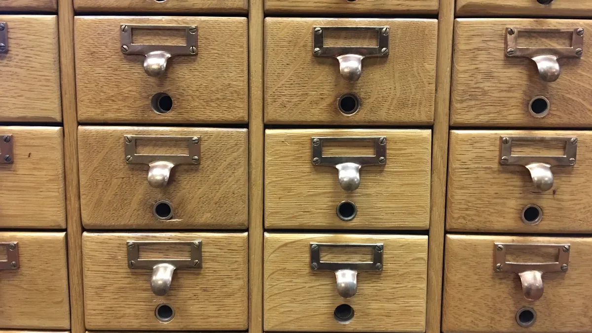 Wooden library card catalog drawers with brass handles