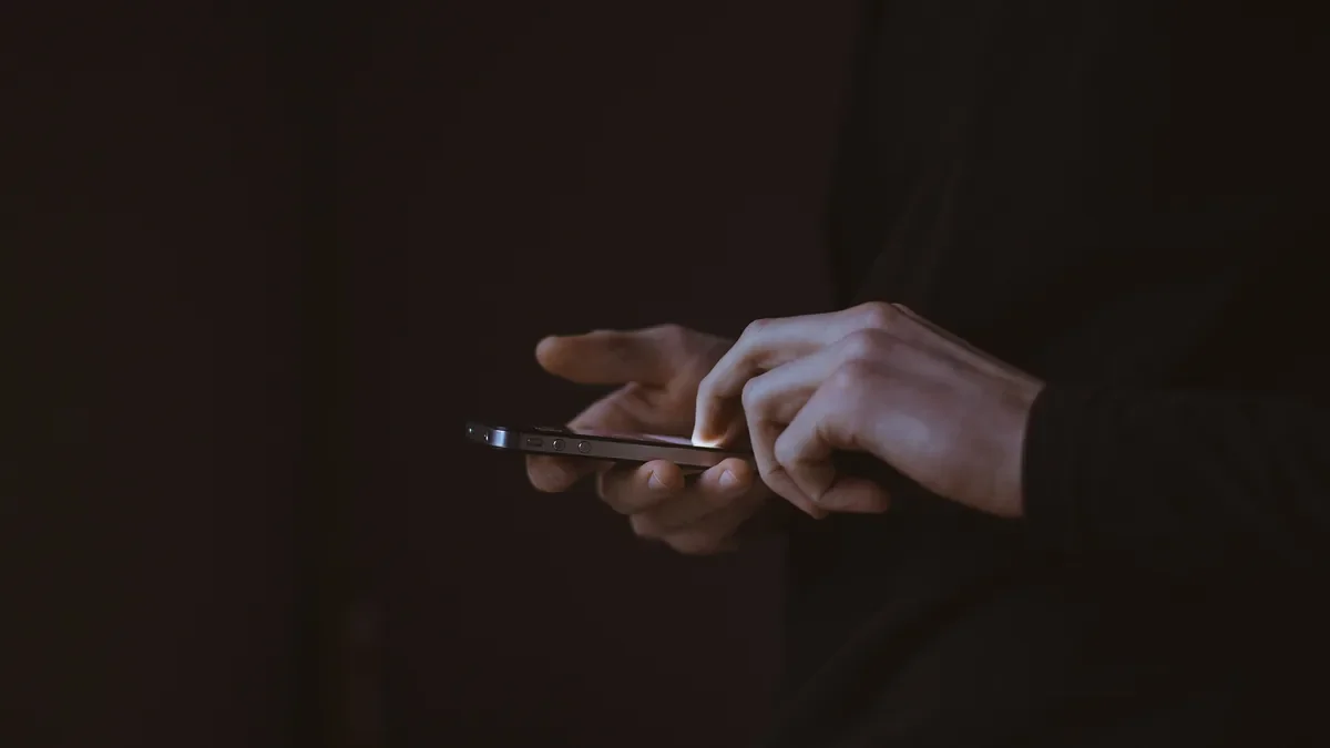 Thumb scrolling a smartphone in a dark room