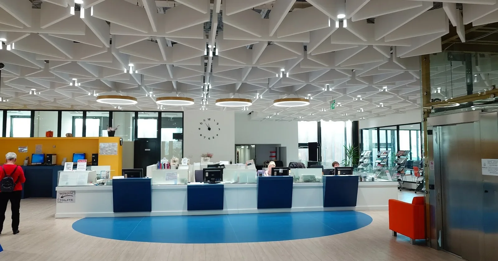 Bright university library reading room with a service desk and ceiling lights